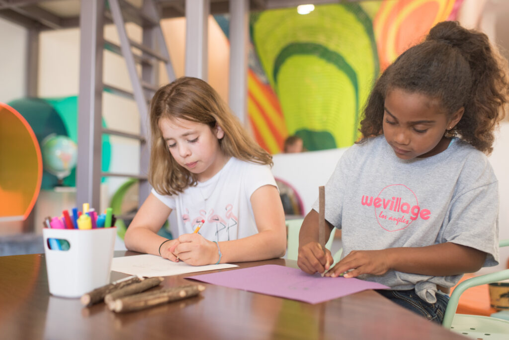 Two young children working together at a table in an inclusive early childhood classroom at WeVillage preschool in Sherman Oaks. Immersive early childhood education.